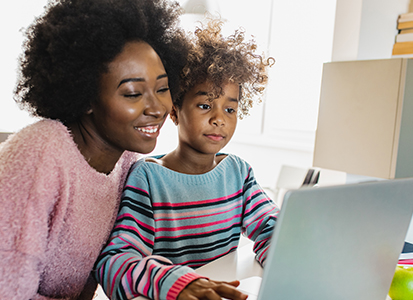 mother next to her child as she helps him with school work