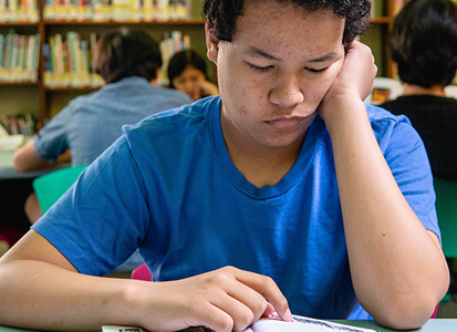 teen studying at the library